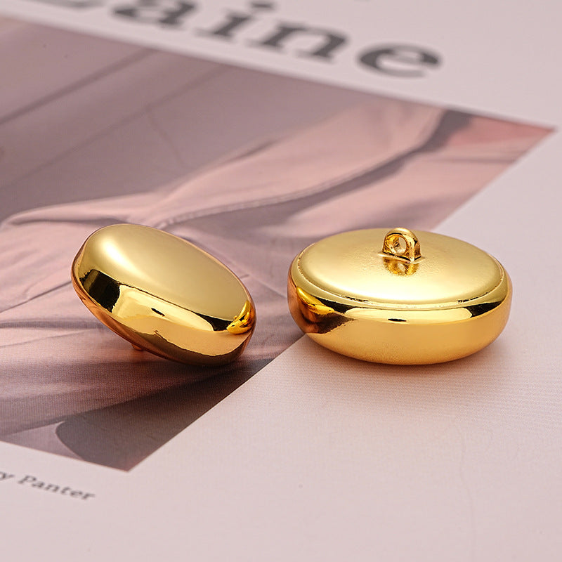 Gold metal decorative button, front and reverse with attachment loop visible