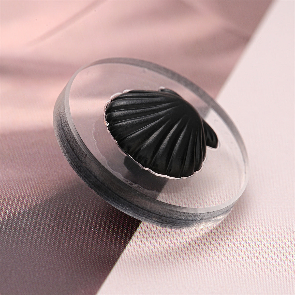 Black shell-style button with ridged texture, metal shank, acrylic front