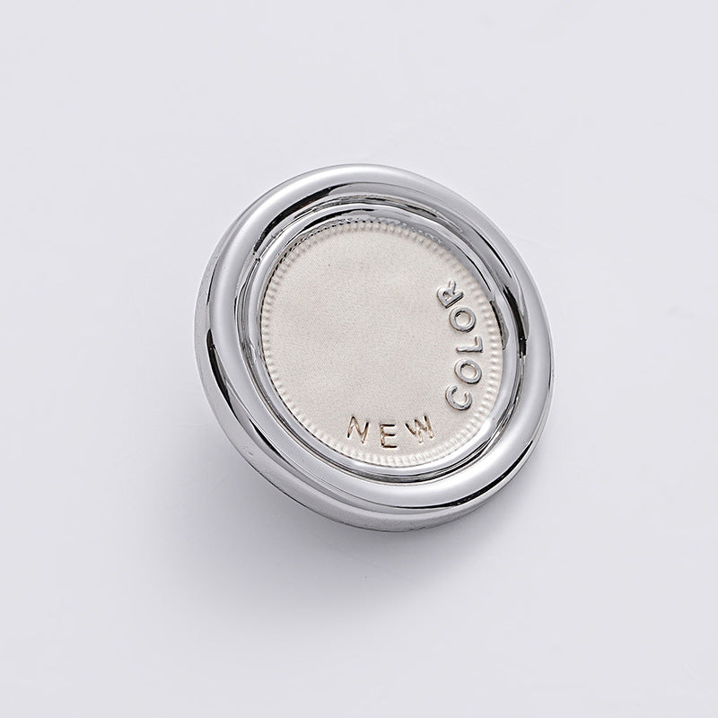 White-silver two-tone round metal sewing button, reverse side with embossed NEW COLOR.