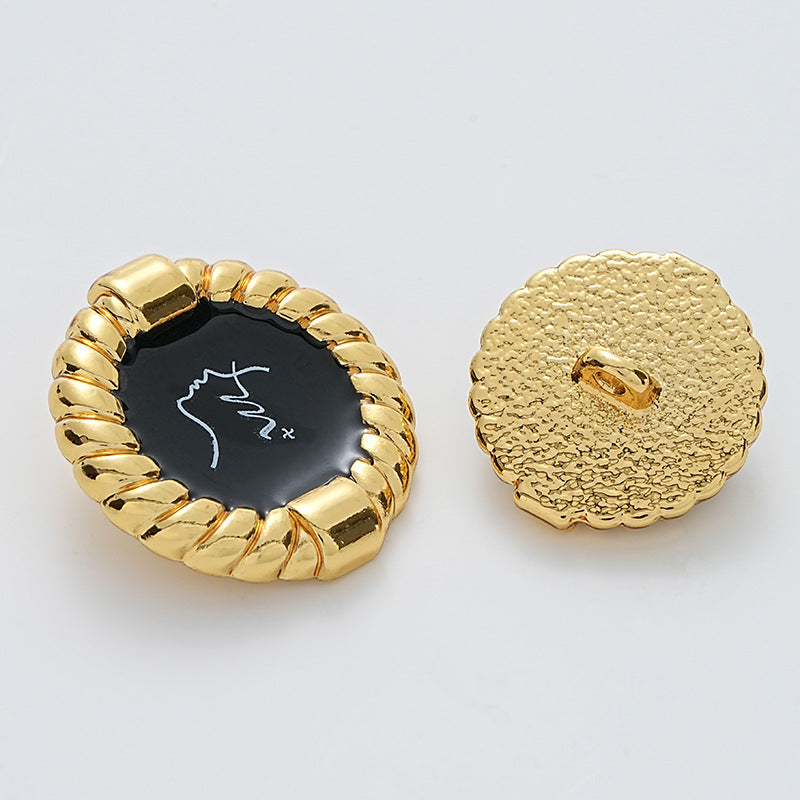 Gold metal button front with black glossy patterned face and visible shank