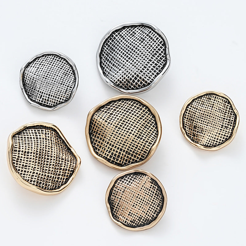 Mixed gold and silver metal buttons with wrinkled corrugated gauze texture surfaces.