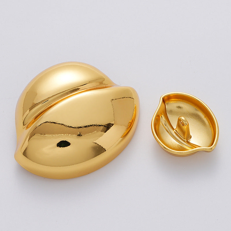 Gold clam-shell metal button with back showing center attachment rivet