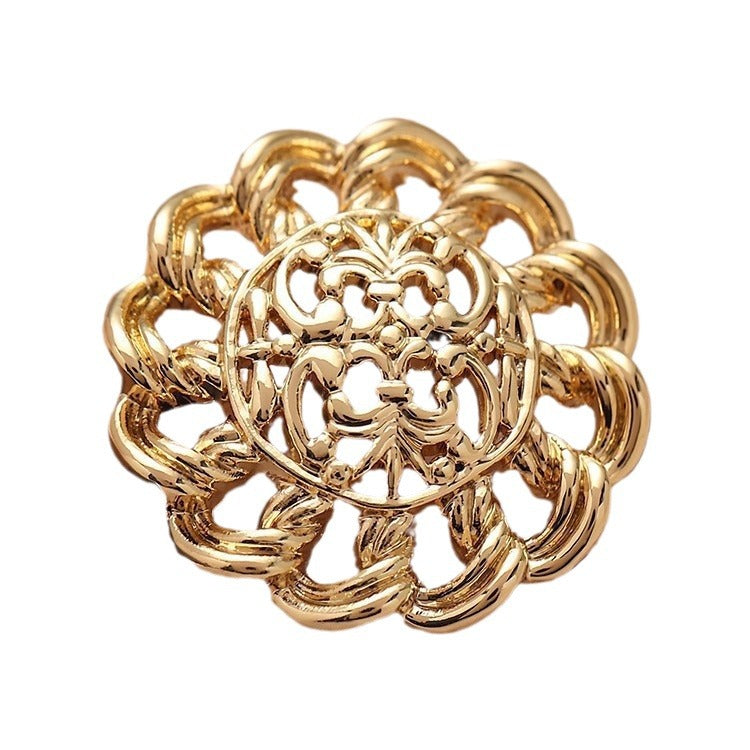 Gold hollow floral metal button with irregular filigree design and ornate cutouts (close-up)