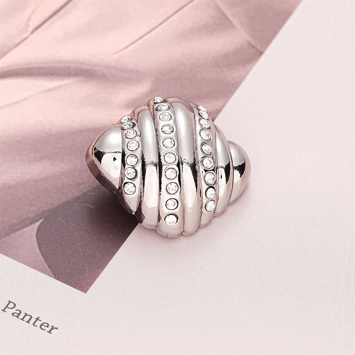 Silver croissant-style metal button with crystal-inlaid vertical ridges, 23mm