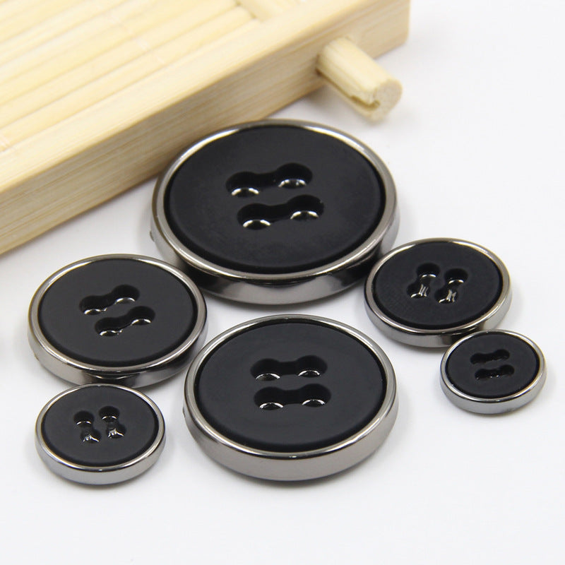 Round black plastic buttons with four-hole design and metal-look edge, mixed sizes