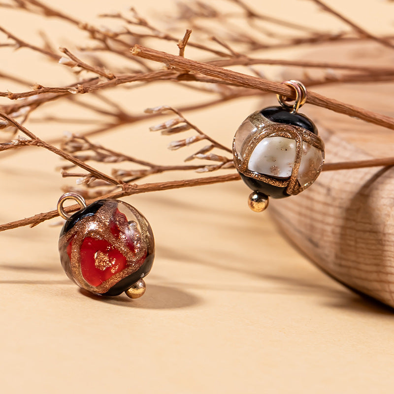 Glazed bead button pair on cord: red center with gold speckle and dark outer glaze