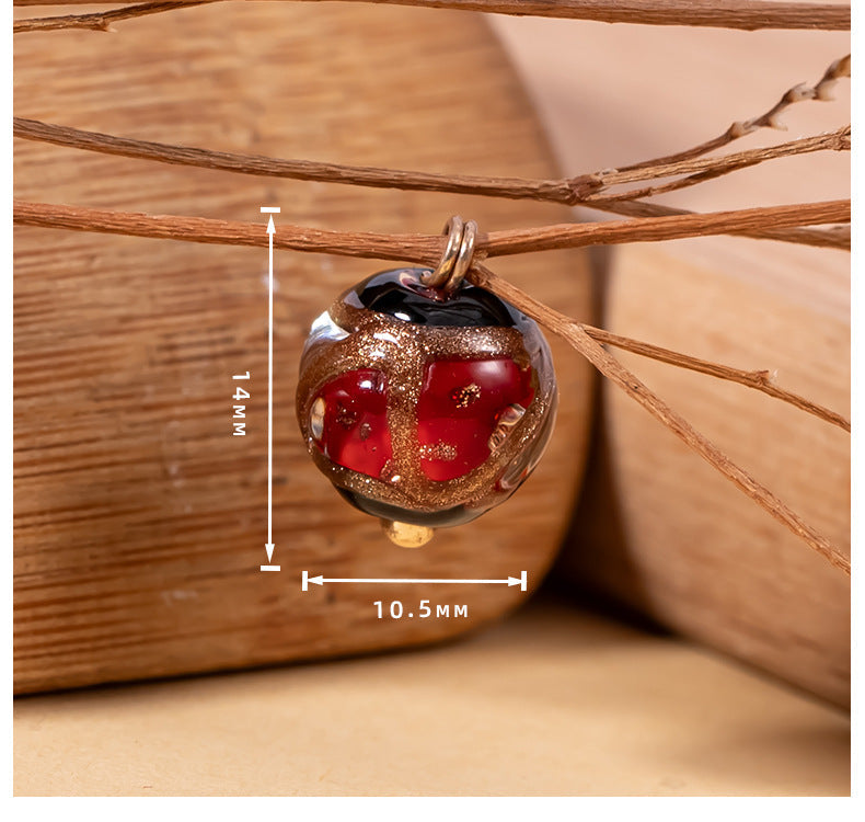 Single glazed apple-shaped bead button with red and gold accents; size marked 10.5 mm