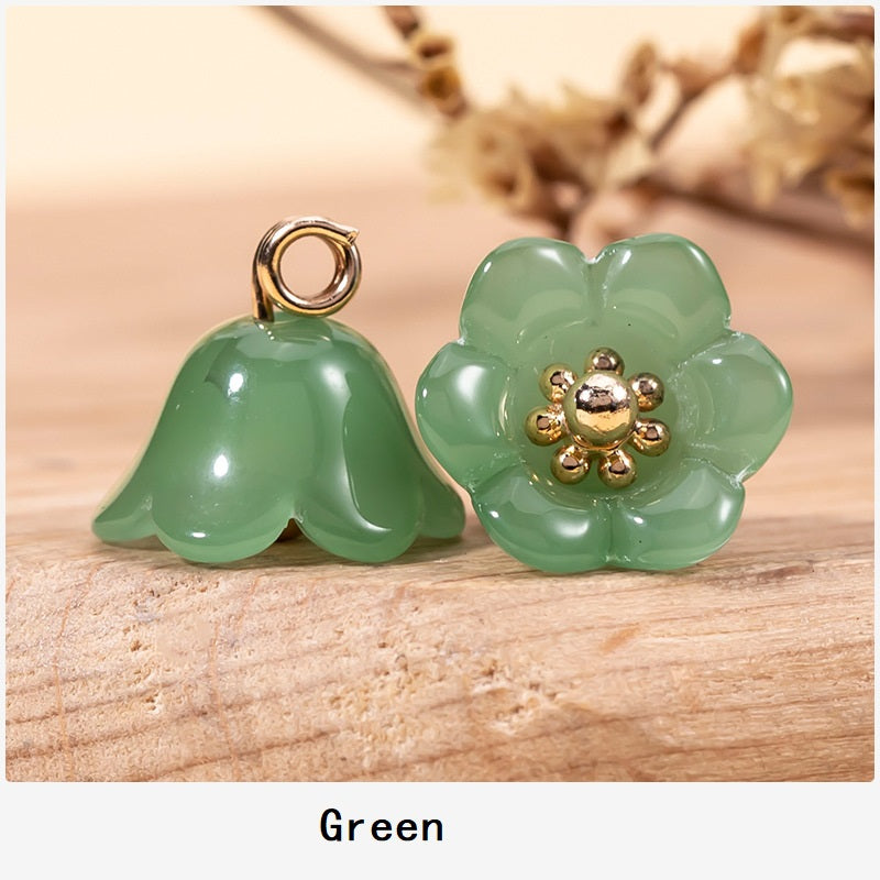 Green lily-of-the-valley glaze buttons with gold-tone floral centers and top loop shanks.