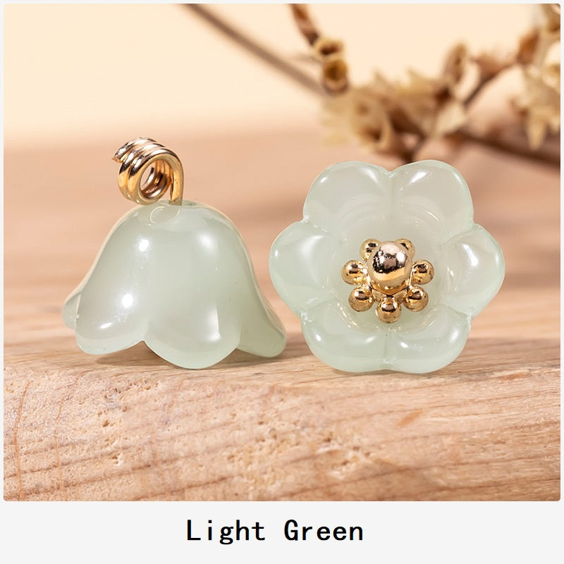 Light green lily-of-the-valley glaze button with gold-tone floral center and loop shank.
