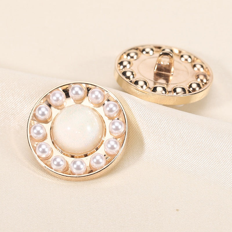 Round pearl resin button, white center with gold rim; front view with back shank showing