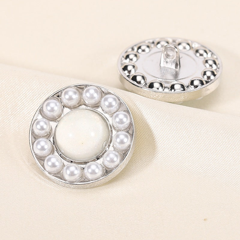 Round pearl resin button, white center with silver rim; front view with back shank showing