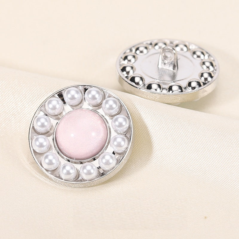 Round pearl resin button, pink center with silver rim; front view with back shank showing