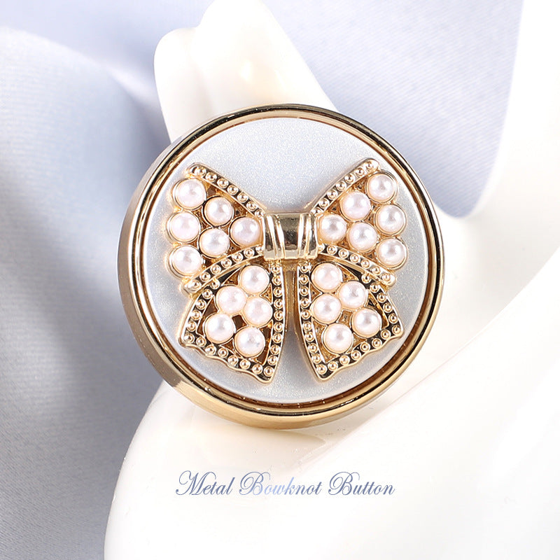 Gold metal shank bowknot button with white faux pearls and sparkling rhinestone trim