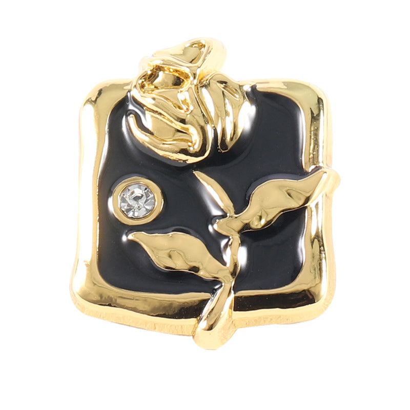 Gold-tone rose rhinestone metal button with black enamel center and 1 clear gem