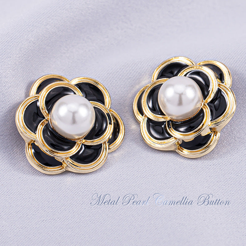 Black camellia metal shank button with round white pearl center and gold-tone frame