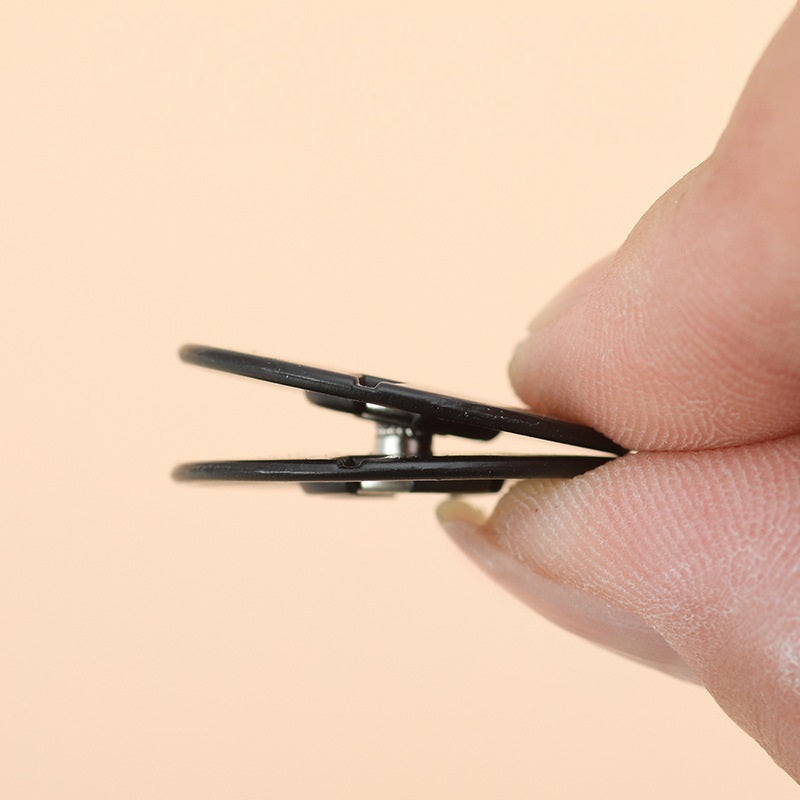 Invisible snap button being pressed with pliers by a fingertip