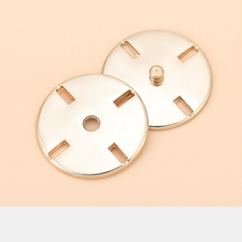 Round metal invisible snap buttons with bar tabs and central snap post, gold tone
