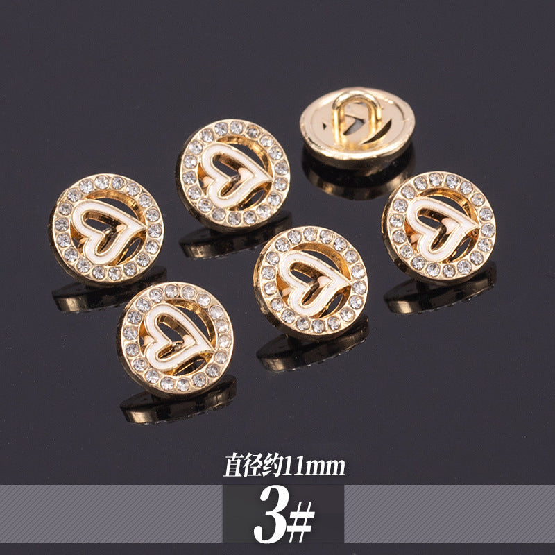 Golden rhinestone shirt buttons with monogram-style cutout in round crystal border; 11-13mm