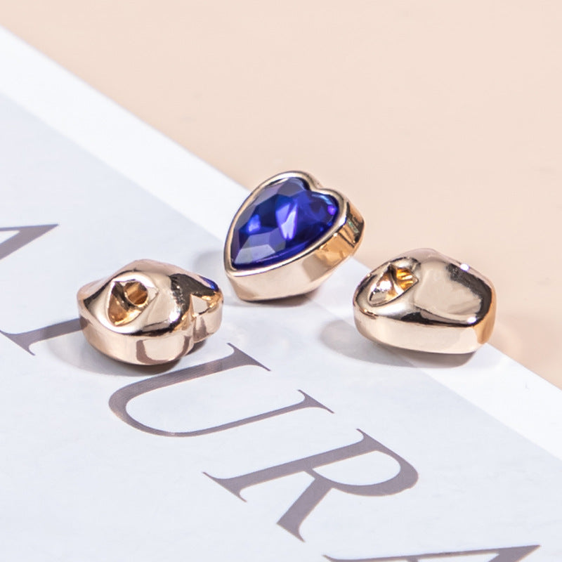 Heart-shaped crystal shirt button, gold-tone metal setting with dark blue faceted stone
