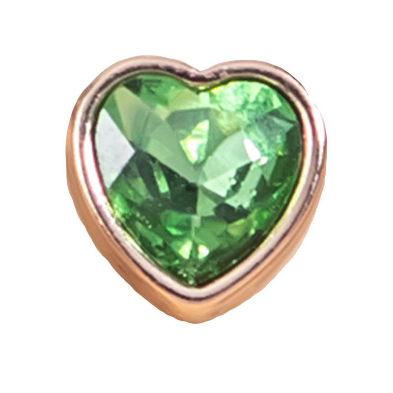 Green heart-shaped crystal shirt button with gold-tone metal bezel and faceted stone