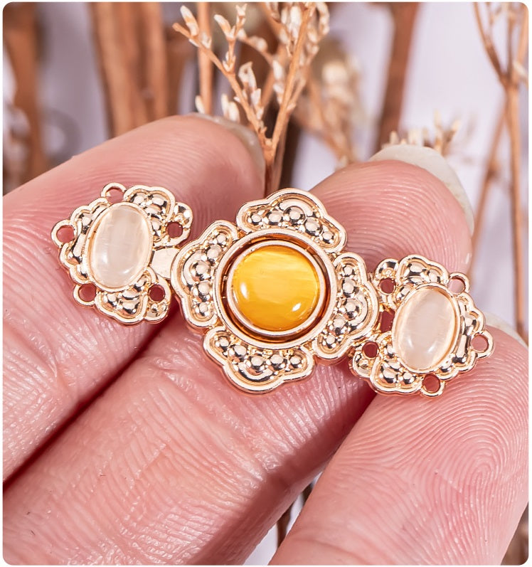 Close-up of embossed flower metal buckle buttons: yellow center with pale pink stones
