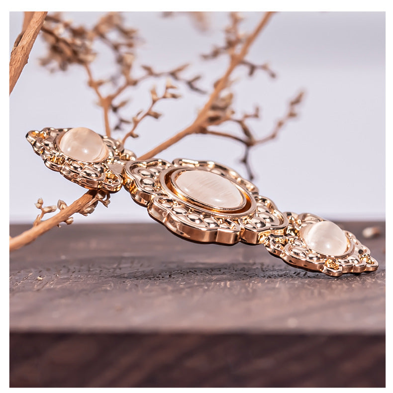 Long row of embossed flower metal buckle buttons with oval pearl and amber stone accents