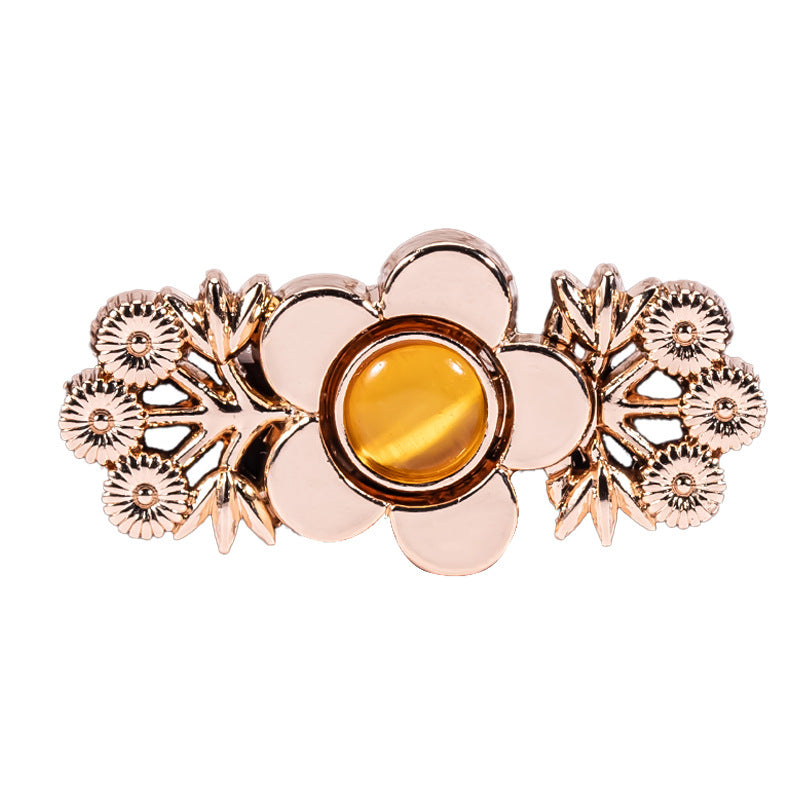 Single branch flower metal lock button with amber cat’s eye center, gold-tone finish