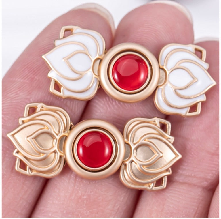 Lotus-Froschverschluss: roter Cat’s-Eye-Cabochon in goldfarbener Fassung mit weißem Lotus-Relief