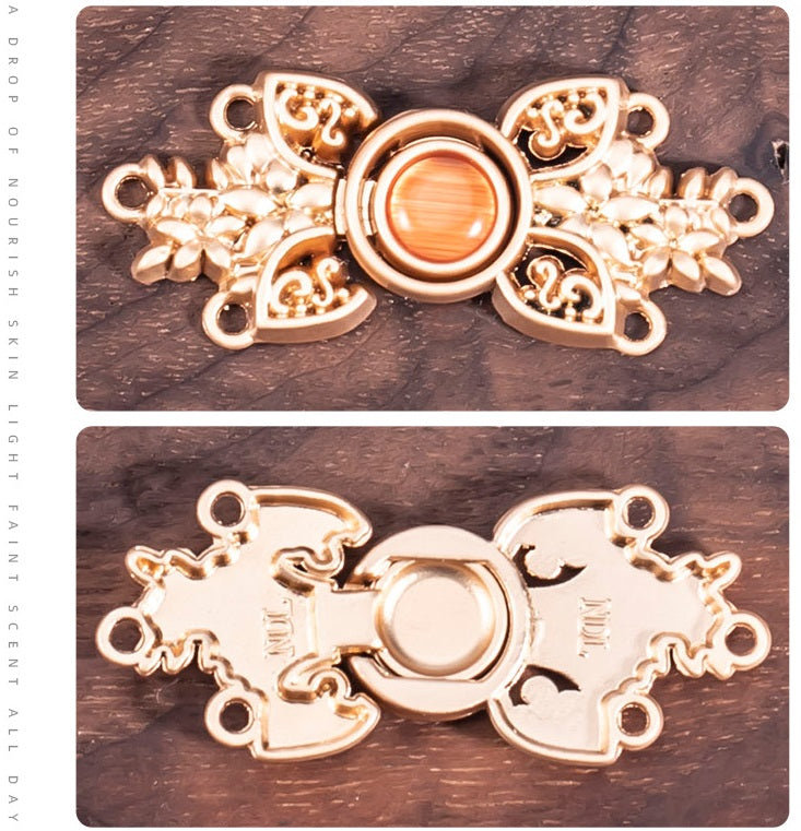 Back view of ornate cat’s eye metal buckle, gold tone with round white/cream center.