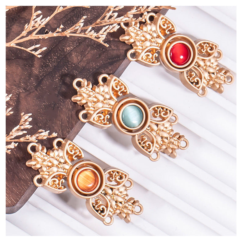 Three metal cat’s eye buckles with ornate filigree, red, green, and orange stones in a set.