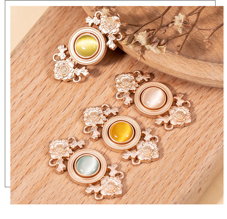 Rose-gold lotus cat’s eye lock buttons with yellow, green, and pink stones on wood
