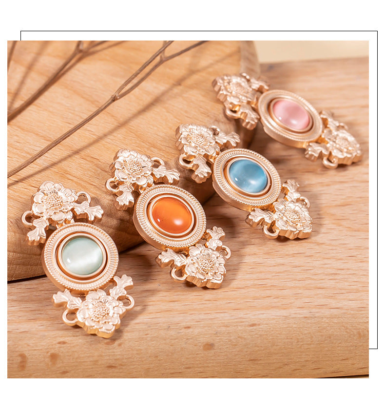 Multiple lotus cat’s eye lock buttons with blue, orange, and pink stones in rose-gold metal