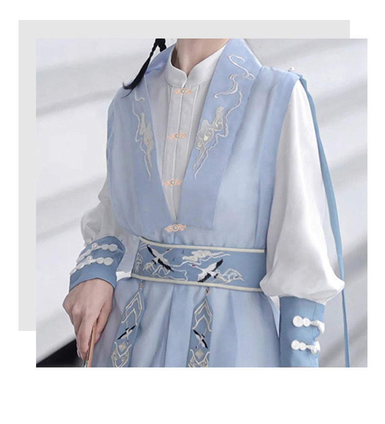 Button detail on light blue garment: ornate metal cat’s-eye style closures