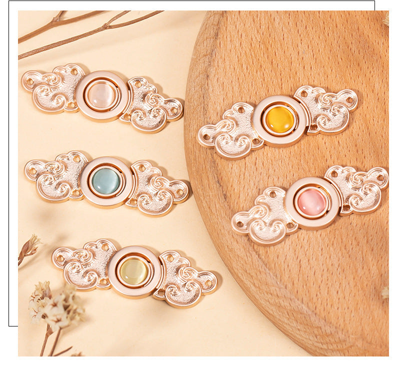 Four ornate metal cat’s-eye buttons with yellow, blue, pink stones on a board (8-pack)