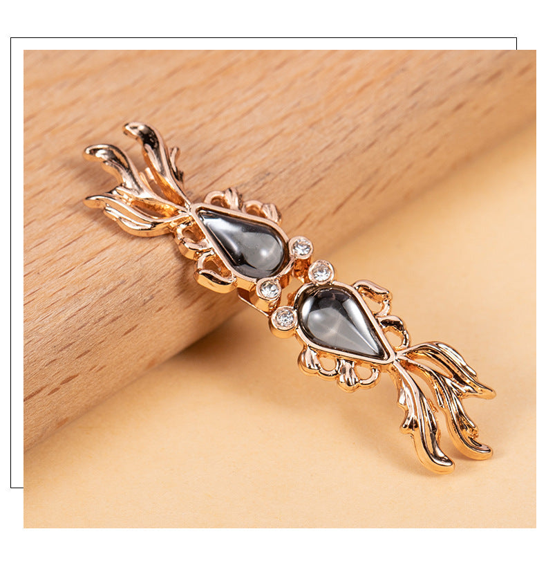 Goldfish-shaped frog closure button with gray cabochon, gold-tone filigree, rhinestones