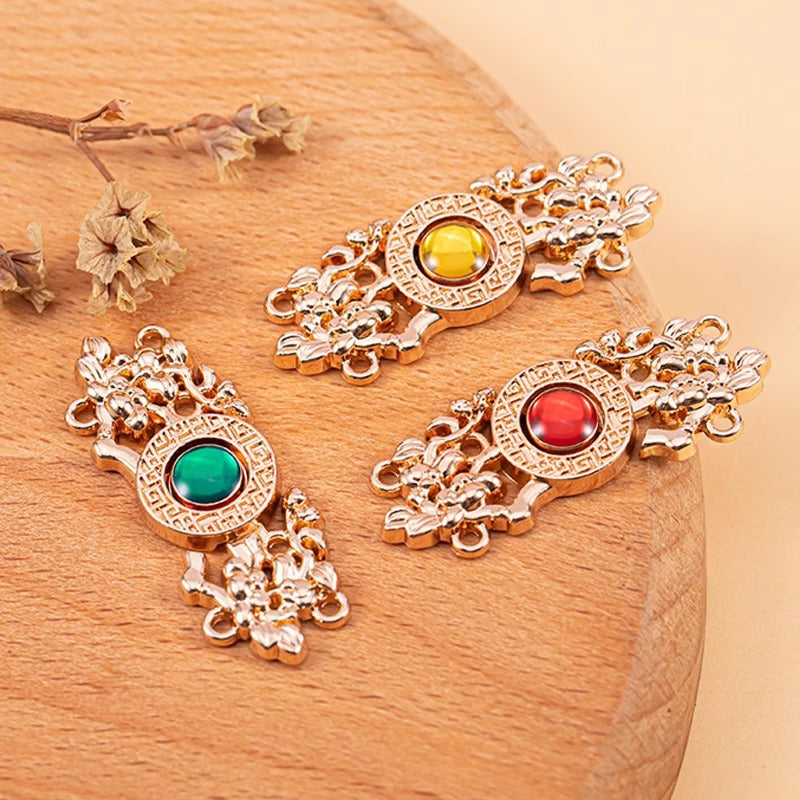 Copper Chinese knot metal button with red and green cat’s-eye stones, ornate filigree