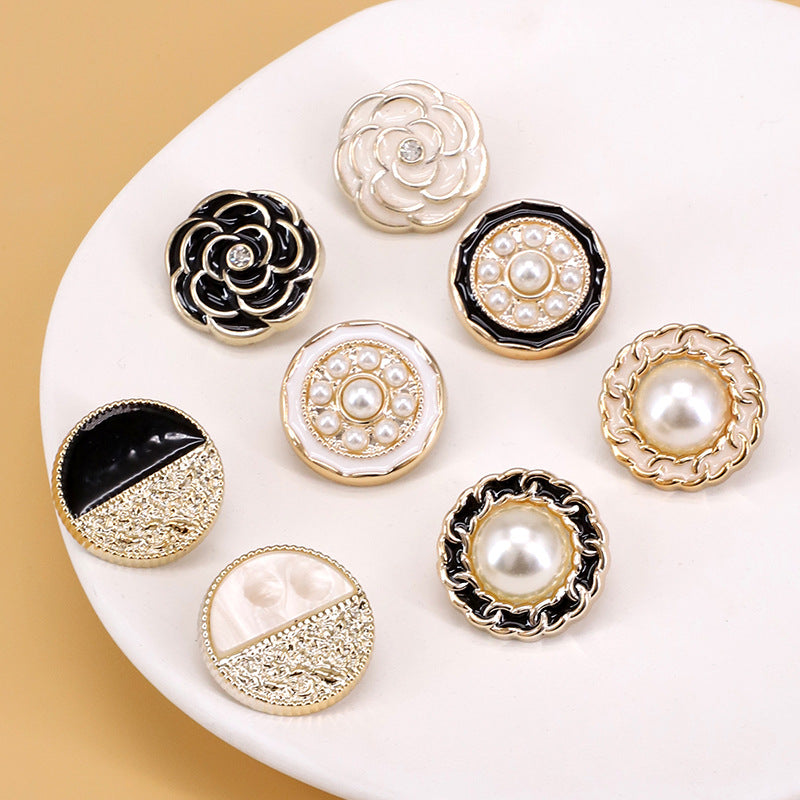 Round decorative shank buttons with white and black enamel, pearl centers, and gold rims