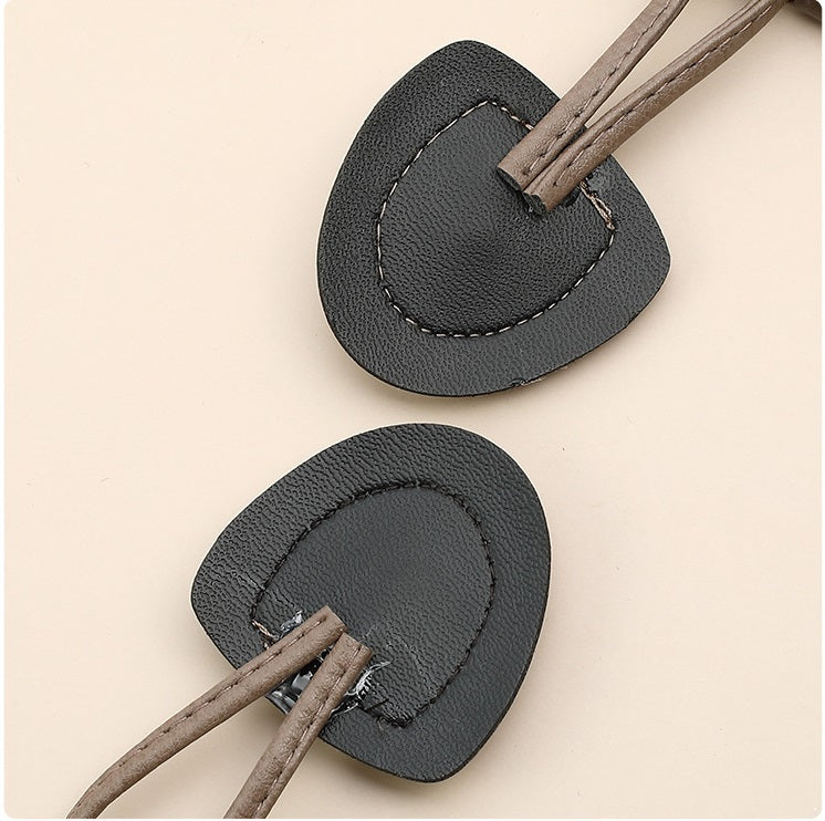 Dark leather horn button with braided cord and stitched loop attachment