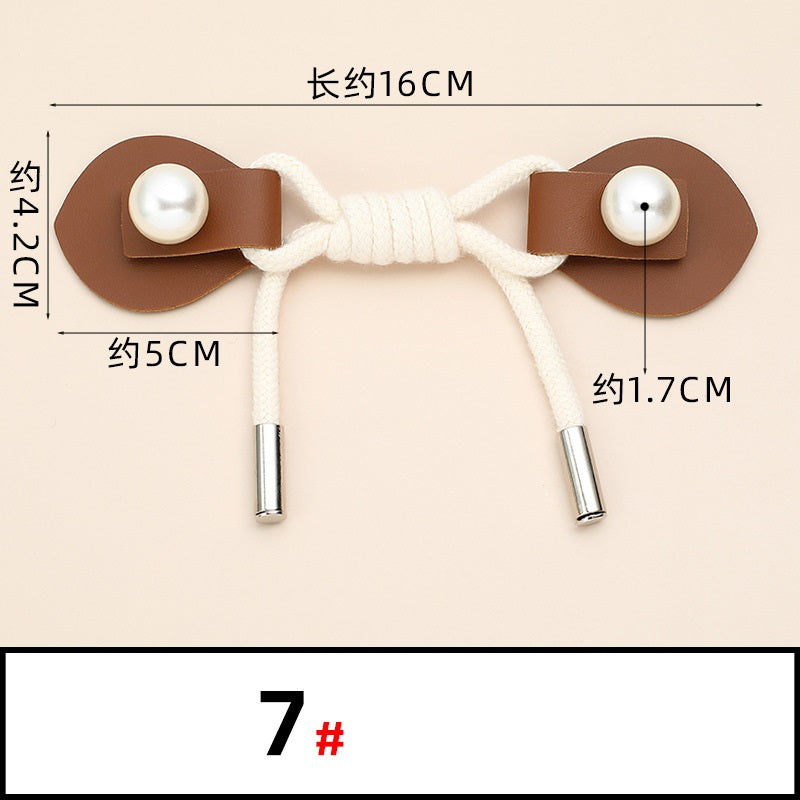Zierknopfband mit Perlmuttknöpfen: braune Leder-Deckplättchen, weiße Kordel, Metallspitzen