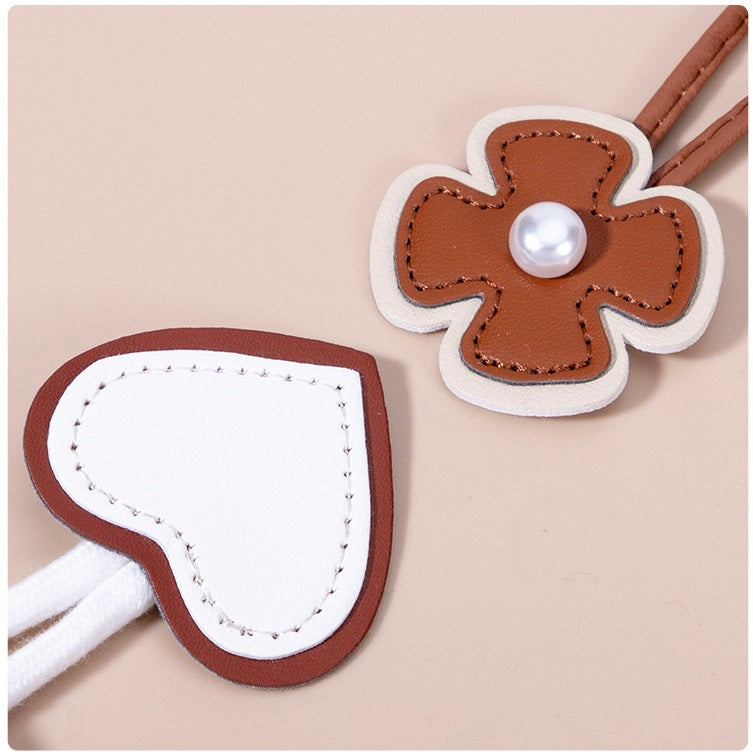 Brown faux leather flower toggle button with faux pearl center and stitched white edge