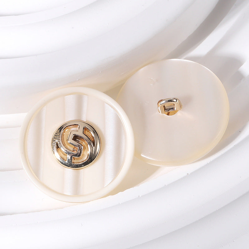 18–25mm round resin button, beige with gold-tone geometric linked pattern