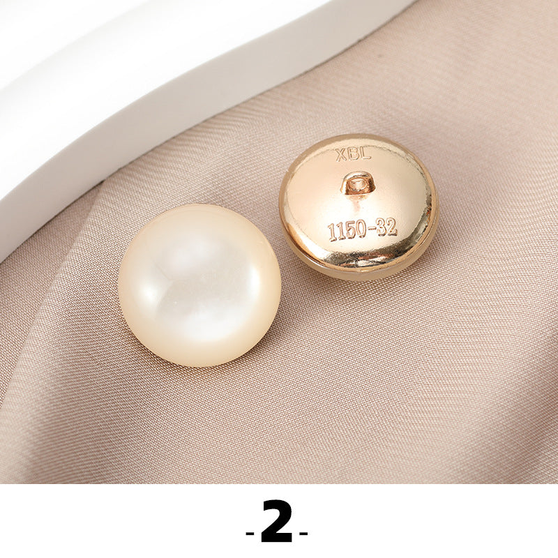 Ivory cat’s eye resin button with gold metal base, back side facing up