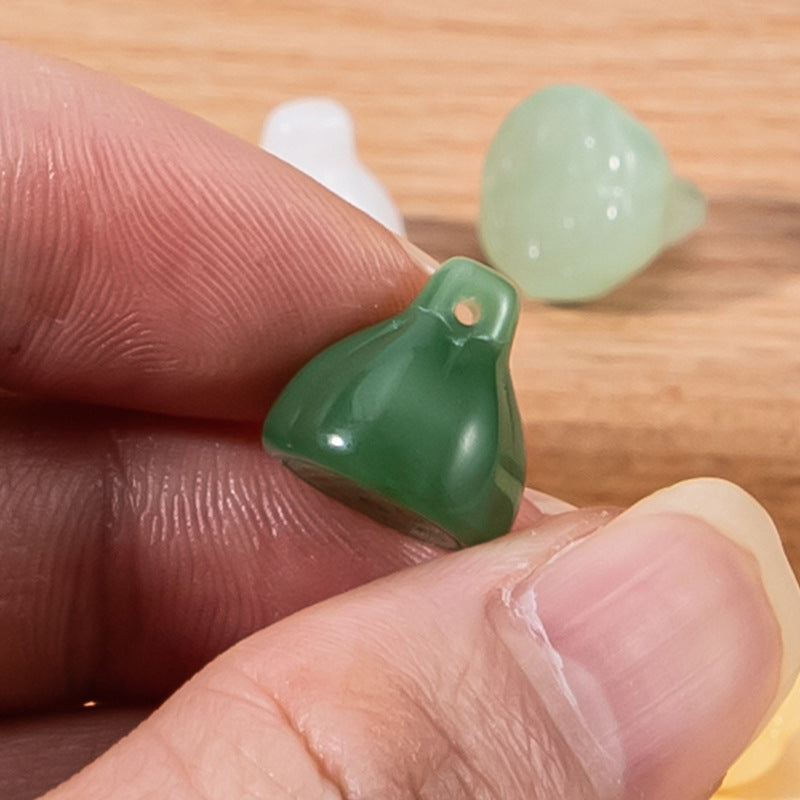 Nahansicht: grüner Glas-Lotusknopf am Finger, mit mintfarbenem Knopf daneben