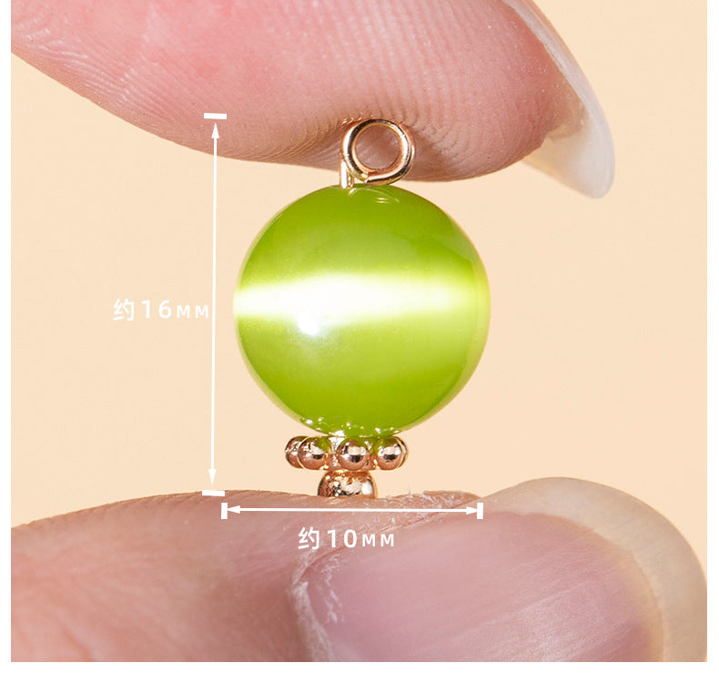 Green cat’s eye stone round button, ~10mm, with gold-tone loop and filigree