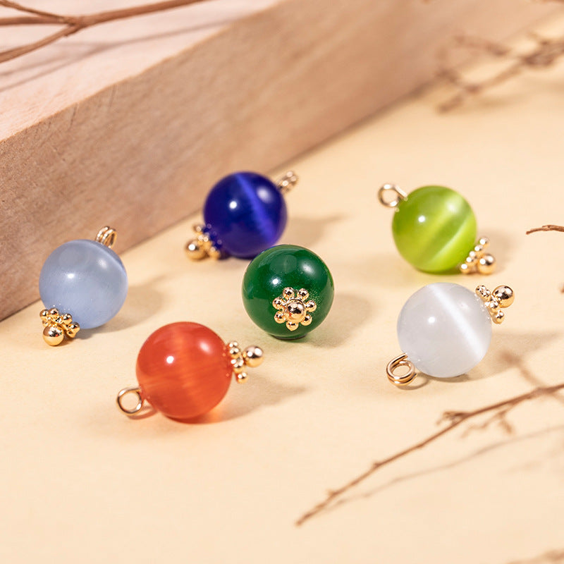 Round cat’s eye stone buttons on a tray: blue, green, red, white, gold-tone mounts