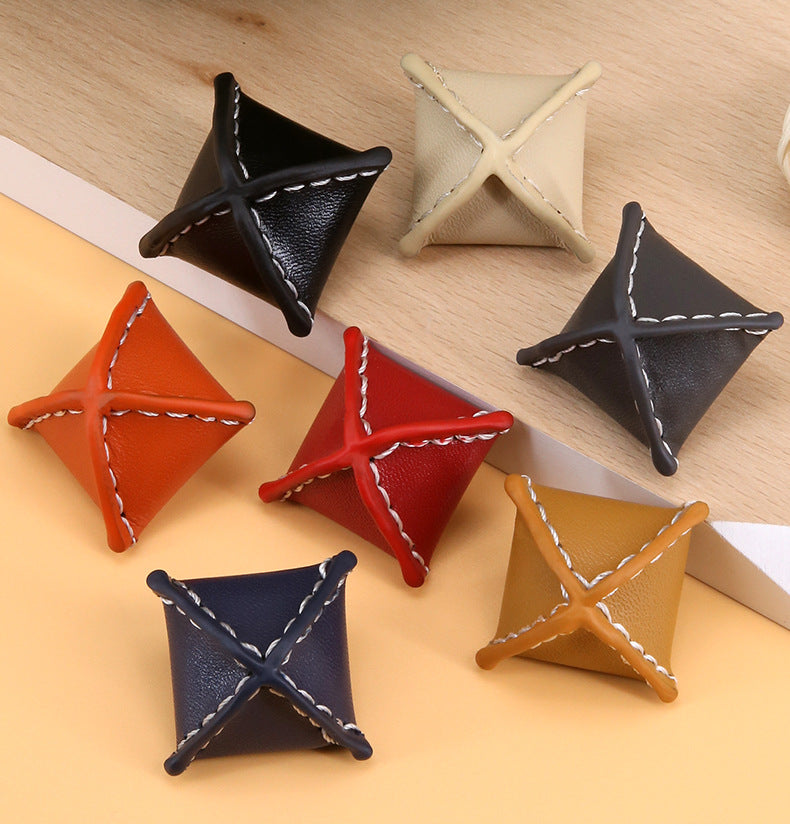 Assorted rhombus leather coat buttons: black, cream, orange, red, navy with stitched X