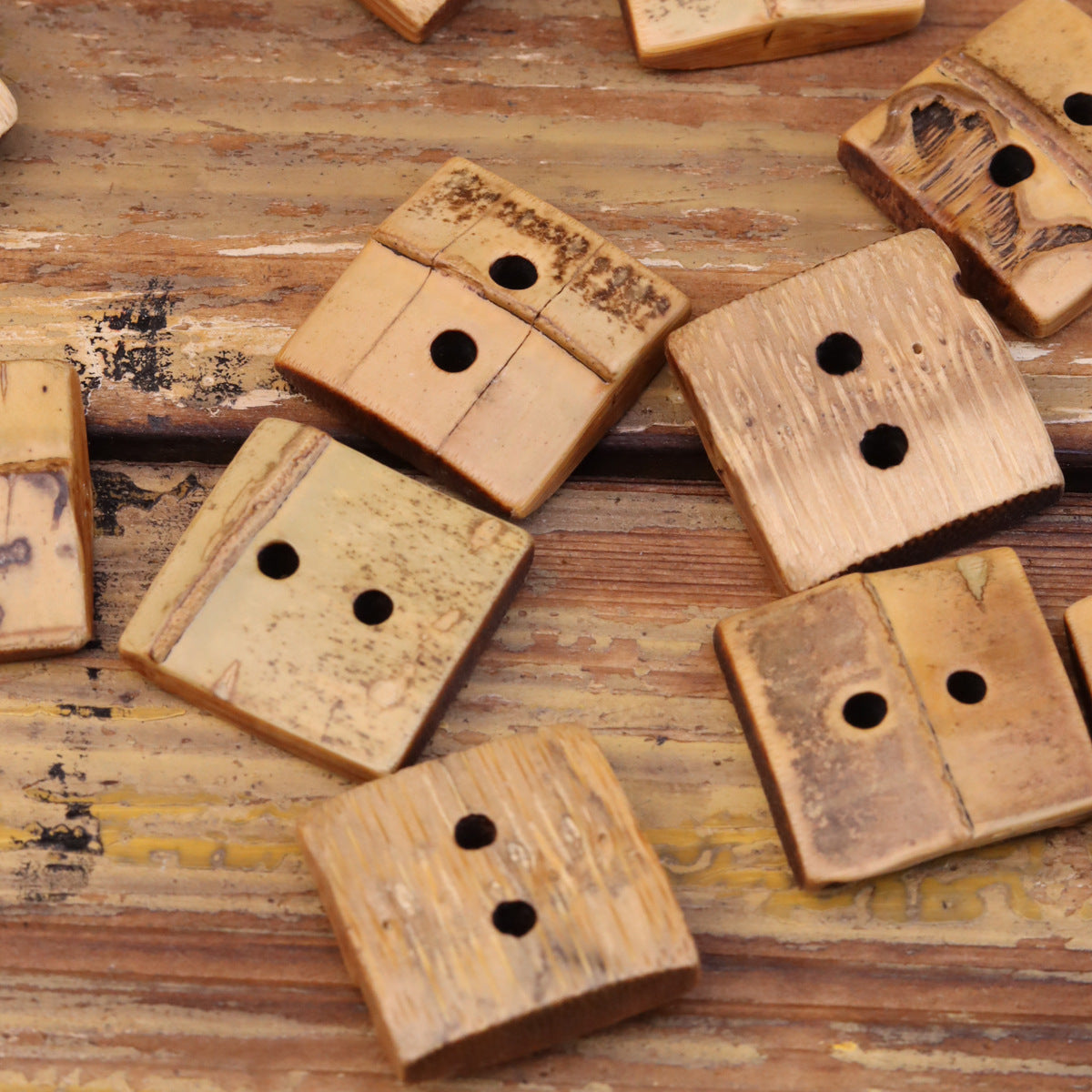 Set of square bamboo two-hole buttons, natural tones, multiple buttons laid out
