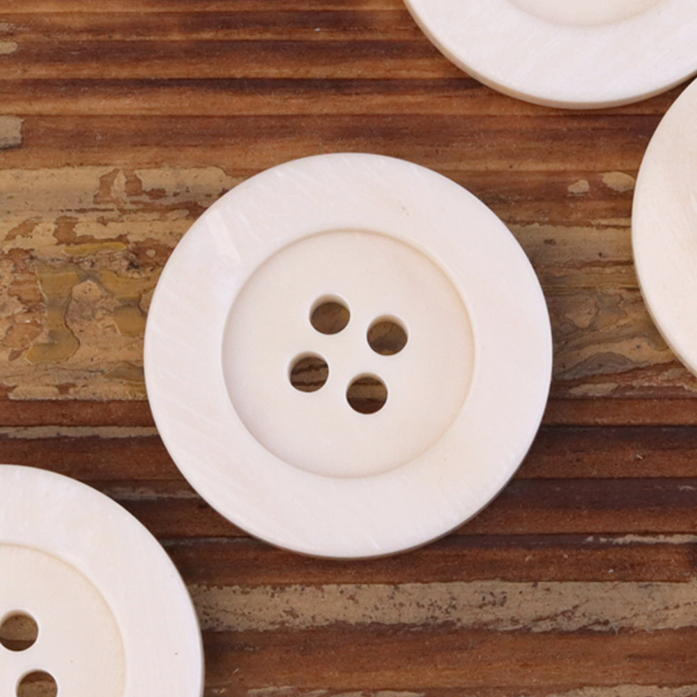 Large light ivory 4-hole bone button with wide edge, front view