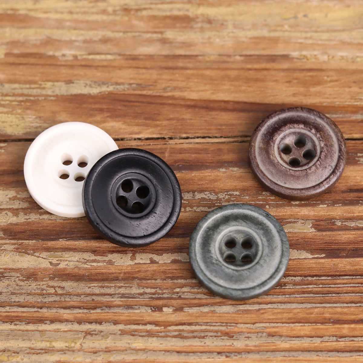 Distressed 4-hole buttons in white, black, gray-green, and brown tones