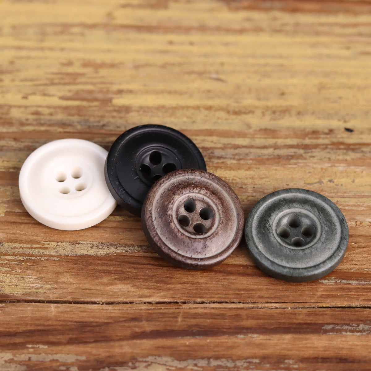 Four-hole distressed buttons: white, black, brown, and gray-green